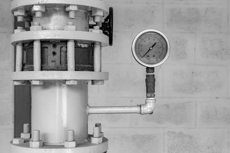 old pressure gauge and steel tube in pump room, black and whiteの写真素材
