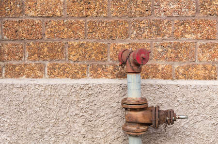 old fire hydrant with laterite wall backgroundの写真素材