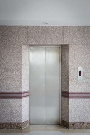 interior of waiting area of elevator with metal door and granite wall and floorの写真素材