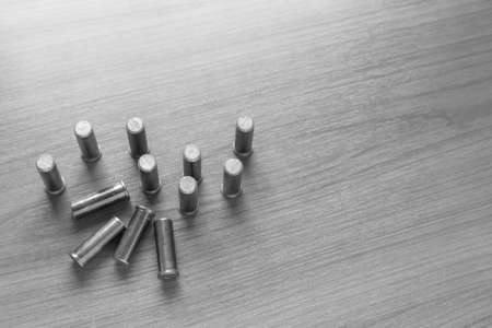 .38 flat head bullet on wooden table with light above, black and white tone, selective focusの写真素材