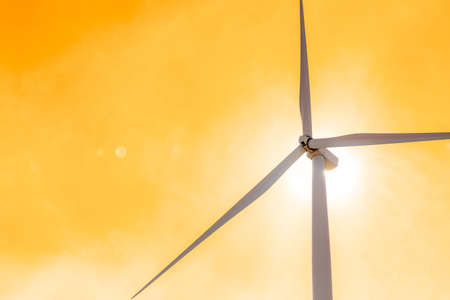 wind turbine in heat area with lens flare effect and sunlight from back sideの写真素材