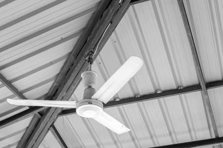 old hanging ceiling fans, black and white tone with metal roof backgroundの写真素材