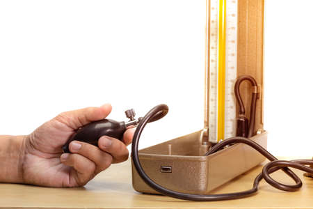 hand holding blood pressure monitor on wood table and white background, edit toneの写真素材