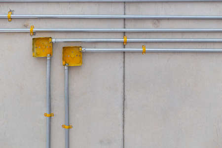 yellow electric steel box and pipe on concrete backgroundの写真素材