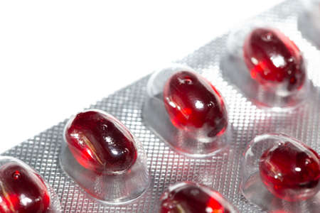 red pills in silver tablet on white background, selective focus, medical and health care conceptの写真素材