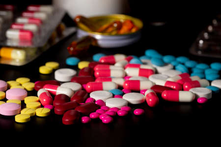 group of pills and bottle of medicine on black background, dangerous medical and health care conceptの写真素材