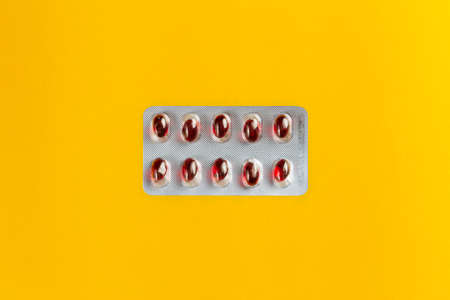 red pills in tablet on yellow background , medical and health care concept objectの写真素材