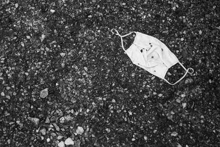 mask textiles abandon on ground, waste used with out responsibility, black and white toneの写真素材