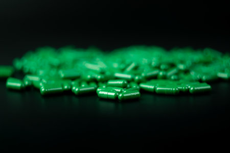 green pills capsule on black bakcground, medical health care conceptの写真素材