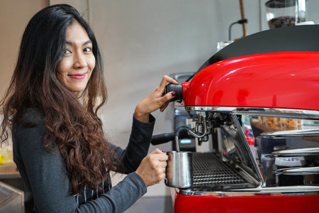 Asian women Barista smiling and using coffee machine in coffee shop counter - Working woman small business owner food and drink cafe conceptの写真素材