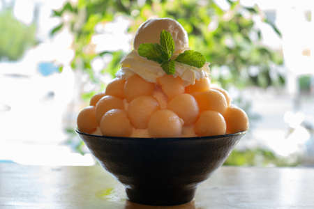 Closeup cantaloupe Bingsu on tray, Bingsu or Bingsoo, Korean shaved ice dessert with sweet toppings...