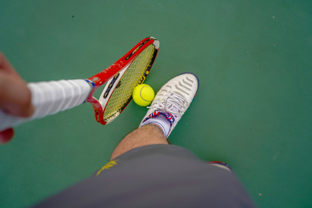 tennis ball and racket on hard courtの写真素材