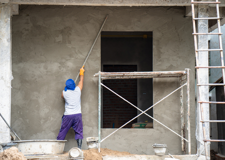 construction workers plastering building wall and beam using cement plaster mix of cement and sand at the construction site in thailandの写真素材