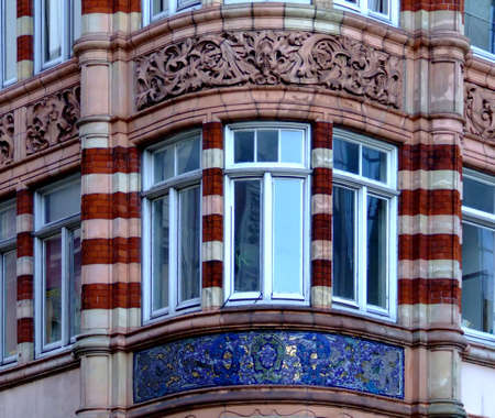 View to a window on the corner of a building with mosaic beneathの写真素材