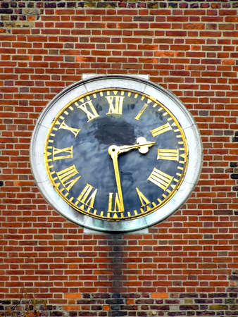 Old clock on a brick wall buildingの写真素材