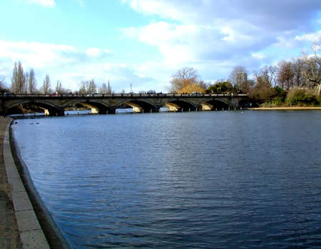 Rippling water surface with a bridge in a backgroundの写真素材