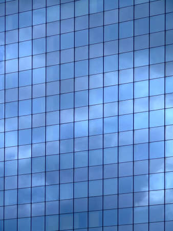 Vertical image of sky reflection on glass wall building