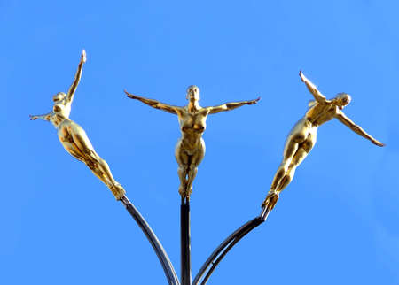 Gold art statue of three swimmersの写真素材