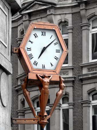 Bronze statue with public clock in old townの写真素材