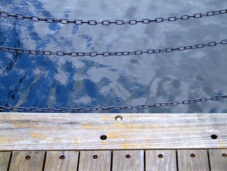 Black chains on wooden dockの写真素材