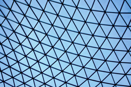 Geometric architectural construction of light blue glass trianglesの写真素材