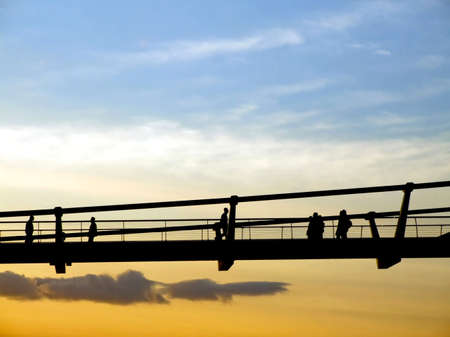 Silhouette of walking people and pedestrian bridgeの写真素材