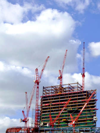 A big construction site with several red cranes