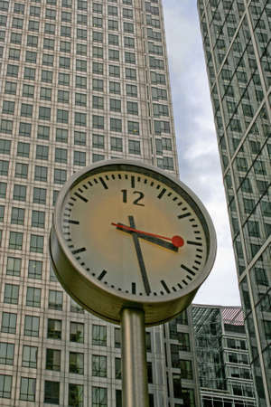 Public clock in front of business buildingの写真素材