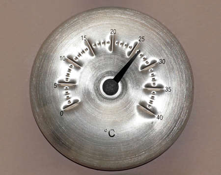 Round aluminum Celsius thermometer on the wall の写真素材