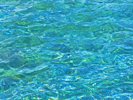 Clear blue pool water surface with wavesの写真素材