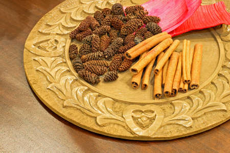 Cinnamon and pinecone decoration on the wooden plate