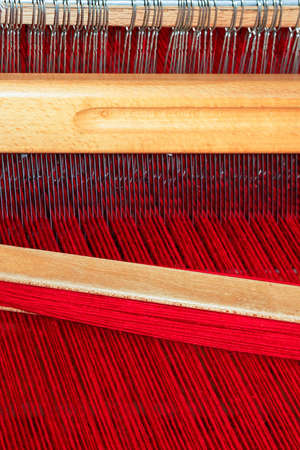 Close up shot of loom with red threadの写真素材