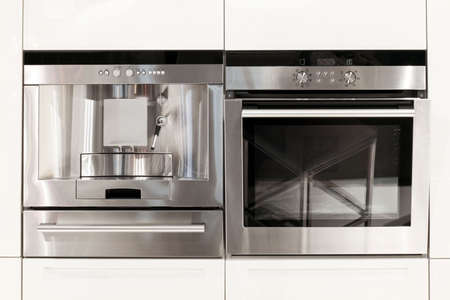 Silver kitchen appliances coffee machine and ovenの写真素材