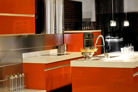 Red kitchen with big counter and metallic appliancesの写真素材