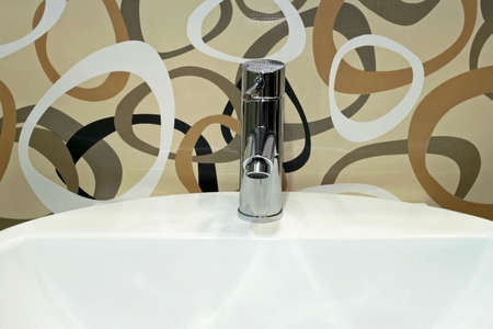 Basin and faucet over modern designed tiles