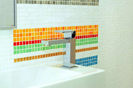 Basin and faucet in bathroom with colourful tilesの写真素材