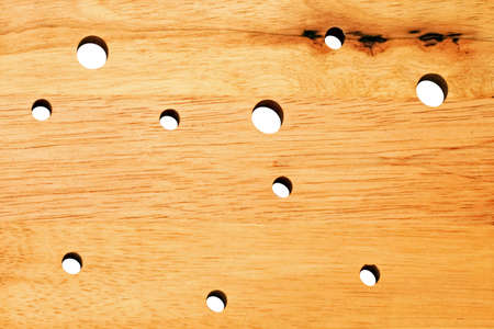 Wooden board in cheese style with holesの写真素材