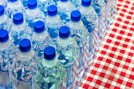 Bunch of plastic water bottles with blue lidsの写真素材