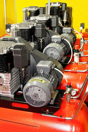 Several red powerful air compressors in lineの写真素材