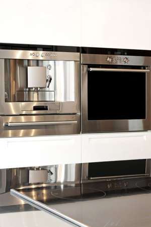 Silver oven and coffee machine in kitchenの写真素材