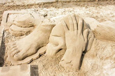 Big sculptures of hand and foot in sandの写真素材