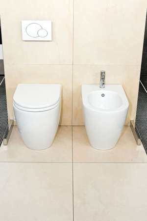 Clean lavatory with toilet seat and wash bowlの写真素材