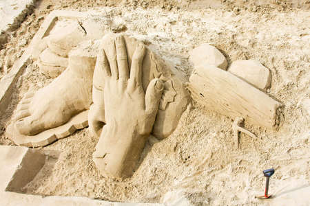 Big sculptures of hand and foot in sandの写真素材