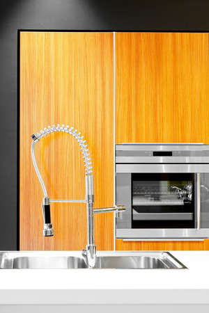 Modern kitchen with metal sink and oven in a backgroundの写真素材
