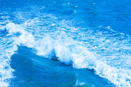 Big waves with foam at blue sea waterの写真素材