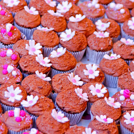 Bunch of chocolate cupcakes with floral ornaments