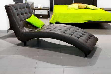 Comfortable leather sofa bed with green pillowの写真素材