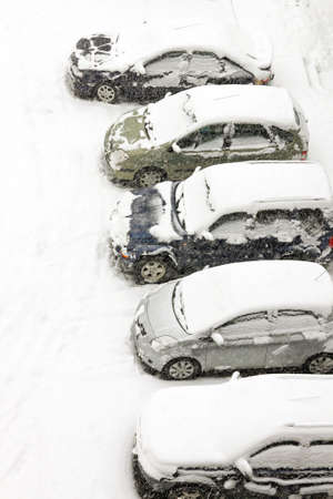 Cars on a street parking covered in snowの写真素材
