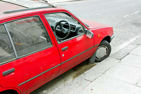 Robbed car parked on a street with smashed windowの写真素材