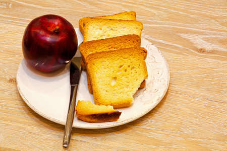 Toast and apple in breakfast plate on tableの写真素材